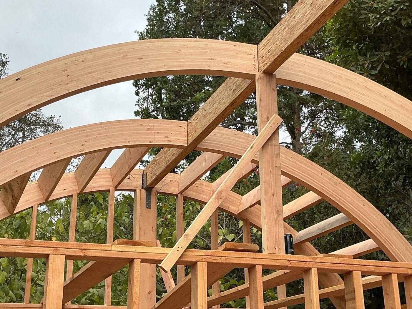 Curved glulam roof beams framed on a detached ADU