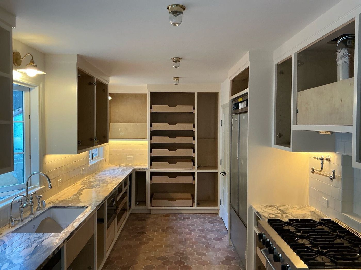 Renovated kitchen with terracotta hex floor and marble counters